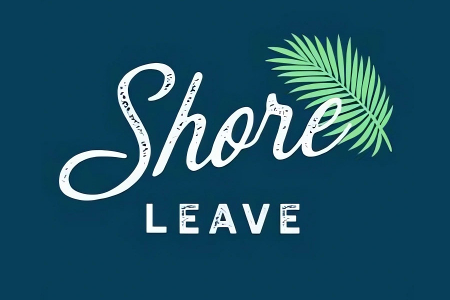 Logo of Shore Leave featuring white lettering with a green tropical palm leaf on a dark blue background.
