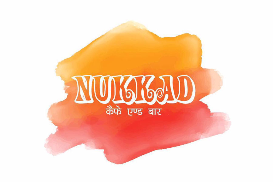 Artistic logo of Nukkad featuring Hindi and English words on a splash of warm colours.