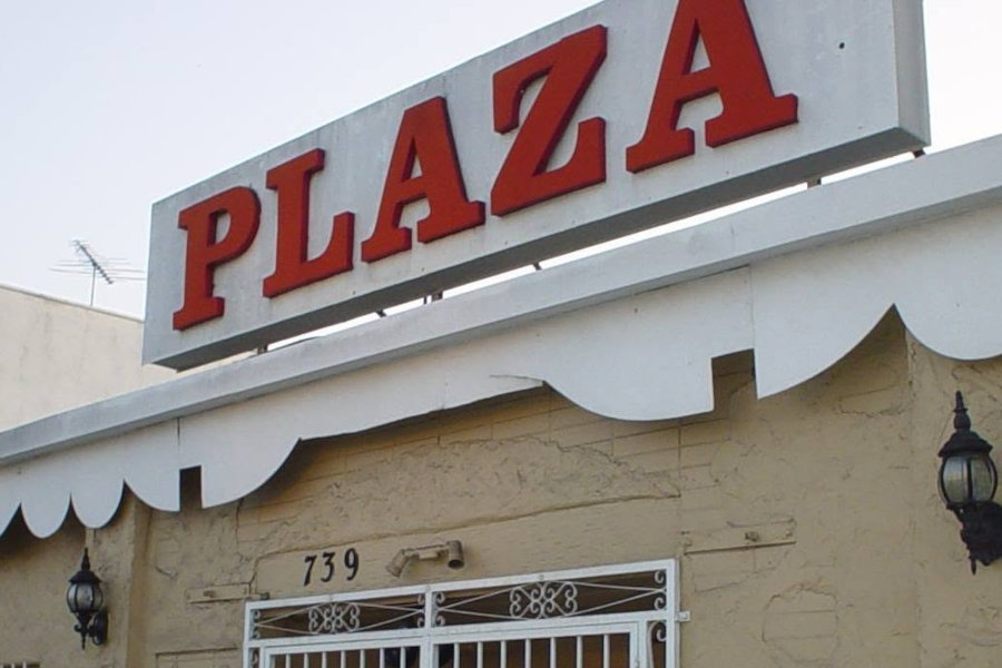 Exterior of Plaza Nightclub in Los Angeles, showing its light-colored facade and large red Plaza sign above the entrance.