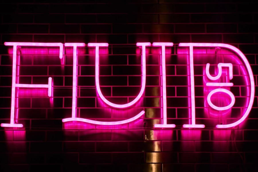 Pink Fluid510 neon sign glowing against a dark tiled wall inside the nightlife venue in Oakland.