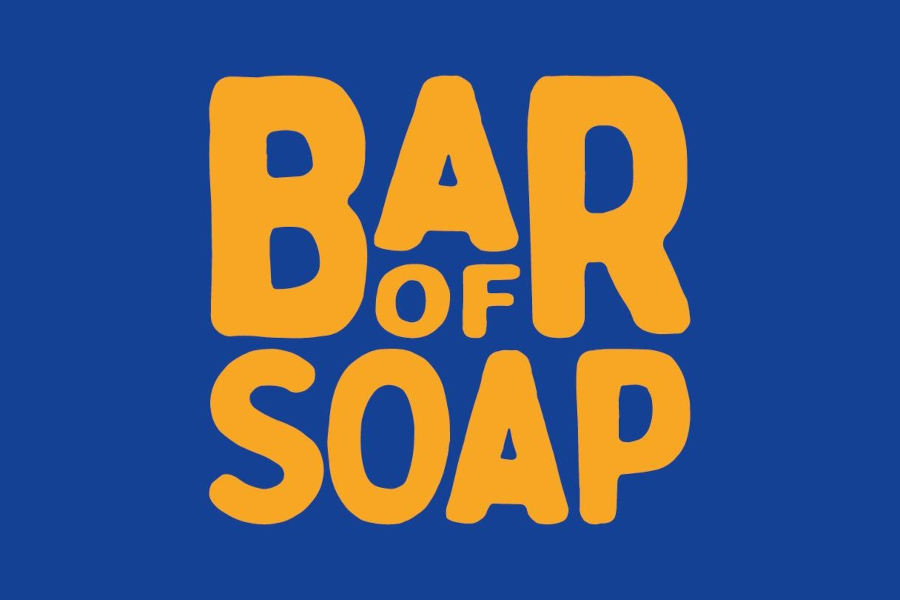 Texto amarelo com a inscrição «Bar of Soap» em negrito, com um tipo de letra divertido, sobre um fundo quadrado azul.