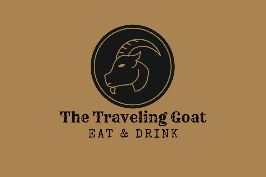 Logo of The Traveling Goat showing a black goat emblem and the words “Eat & Drink” on a tan backdrop.