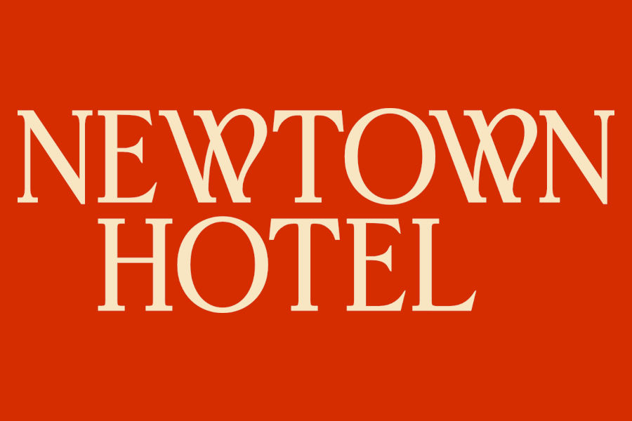 Logo of Newtown Hotel with centered white serif lettering against a bright red background, emphasizing simple branding.